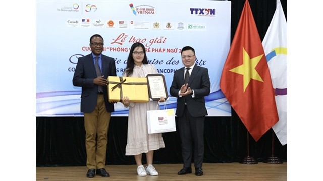 Le vice-directeur général de la VNA, Lê Quôc Minh (droite), et le représentant du BRAP-OIF, Chékou Oussouman, remettent des prix à Man Khanh Ly, lauréate du premier prix. Photo : Hoàng Hiêu/VNA.