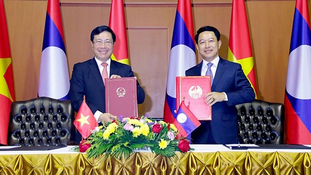 Le ministre laotien des Affaires étrangères Saleumsay Kommasith (à droite) et Vice-Premier ministre et ministre vietnamien des Affaires étrangères, Pham Binh Minh (à gauche). Photo : VNA.