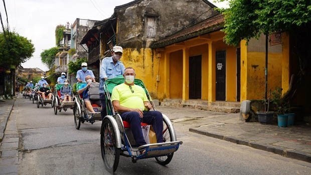 Des touristes étrangers visitent la vieille ville de Hôi An. Photo : VNA.