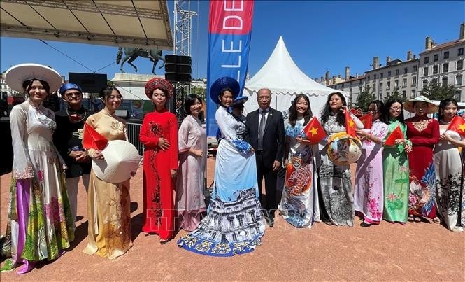 Défilé de l'"áo dài" vietnamien lors des fêtes consulaires de Lyon 2022. Photo : VNA.