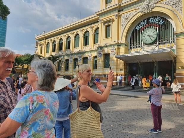 Des touristes étrangers devant la Poste centrale de Saigon. Photo : NLD.
