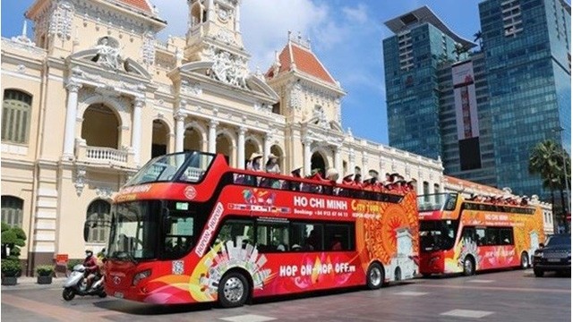 Des touristes visitent Hô Chi Minh-Ville en bus. Photo : VNA.
