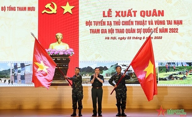 Le général Thai Van Minh, chef du Service de formation militaire (au milieu), remet des drapeaux nationaux à des représentants des deux équipes. Photo : qdnd.vn